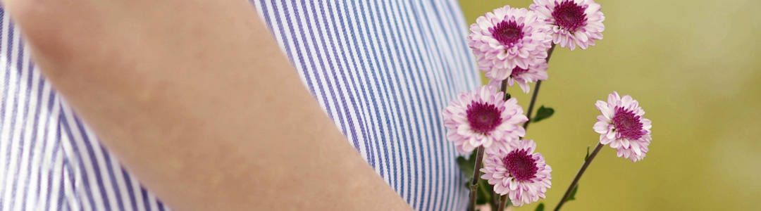 Pregnant woman holding wild flowers Pregnant woman holding wild flowers